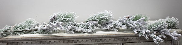 Snow flocked evergreen garland with pine cones.