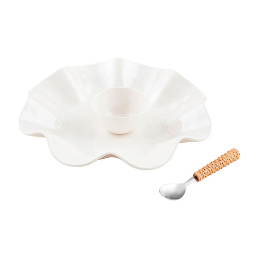 The Ruffled Melamine Chip & Dip Set is a white, flower-shaped dish featuring a central dip bowl and ruffled edge. It comes with a spoon, which has a shiny metal head and woven cane handle. The set is dishwasher safe. Available sizes: One size only.