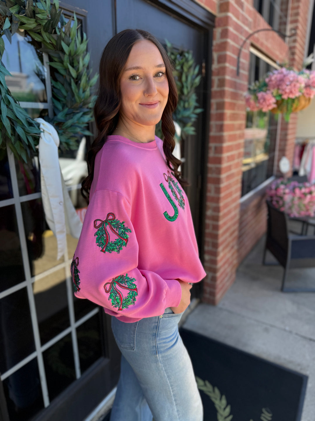 Pink Sarah Joy Wreath sweatshirt with sequined Christmas wreath sleeve graphics.