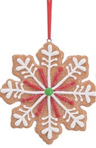 Snowflake-shaped gingerbread ornament with white icing, red accents, and a green center bead on a red ribbon.
