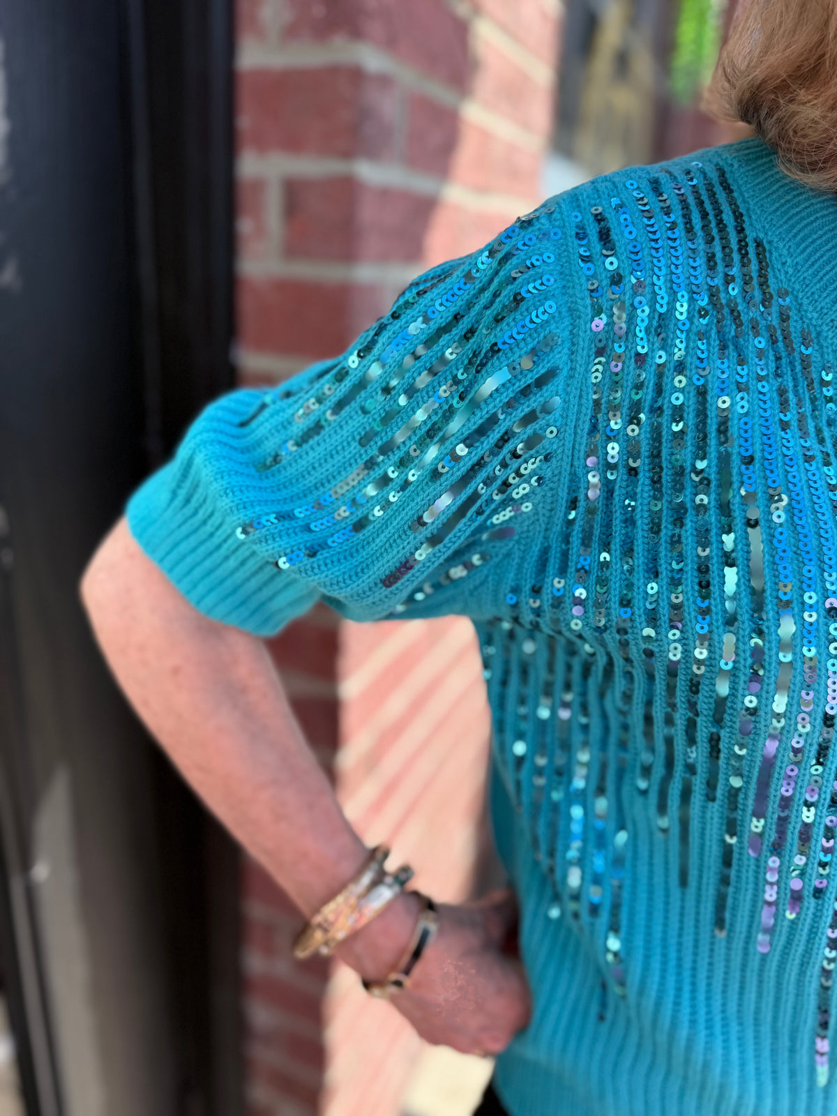 Rosalie Sequin Blouse: teal knit sweater with floral sequin detailing, available in sizes XS–XL.