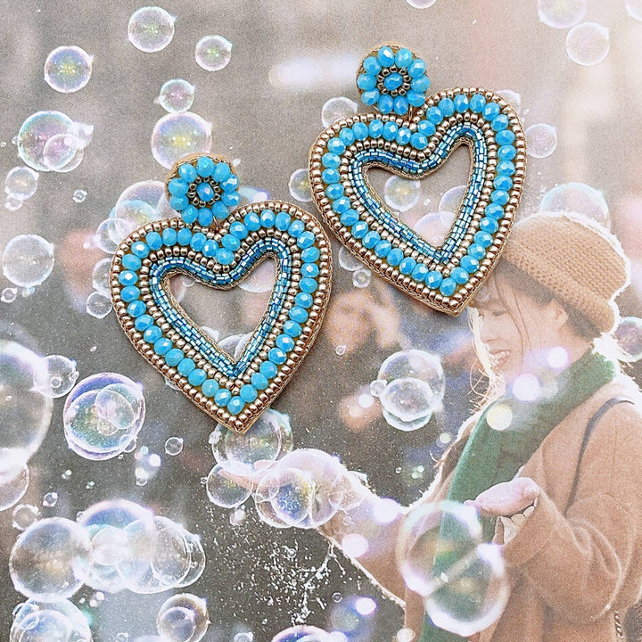 Two blue heart earrings made of seed beads and 24k gold plating. Available in small, medium, and large sizes.