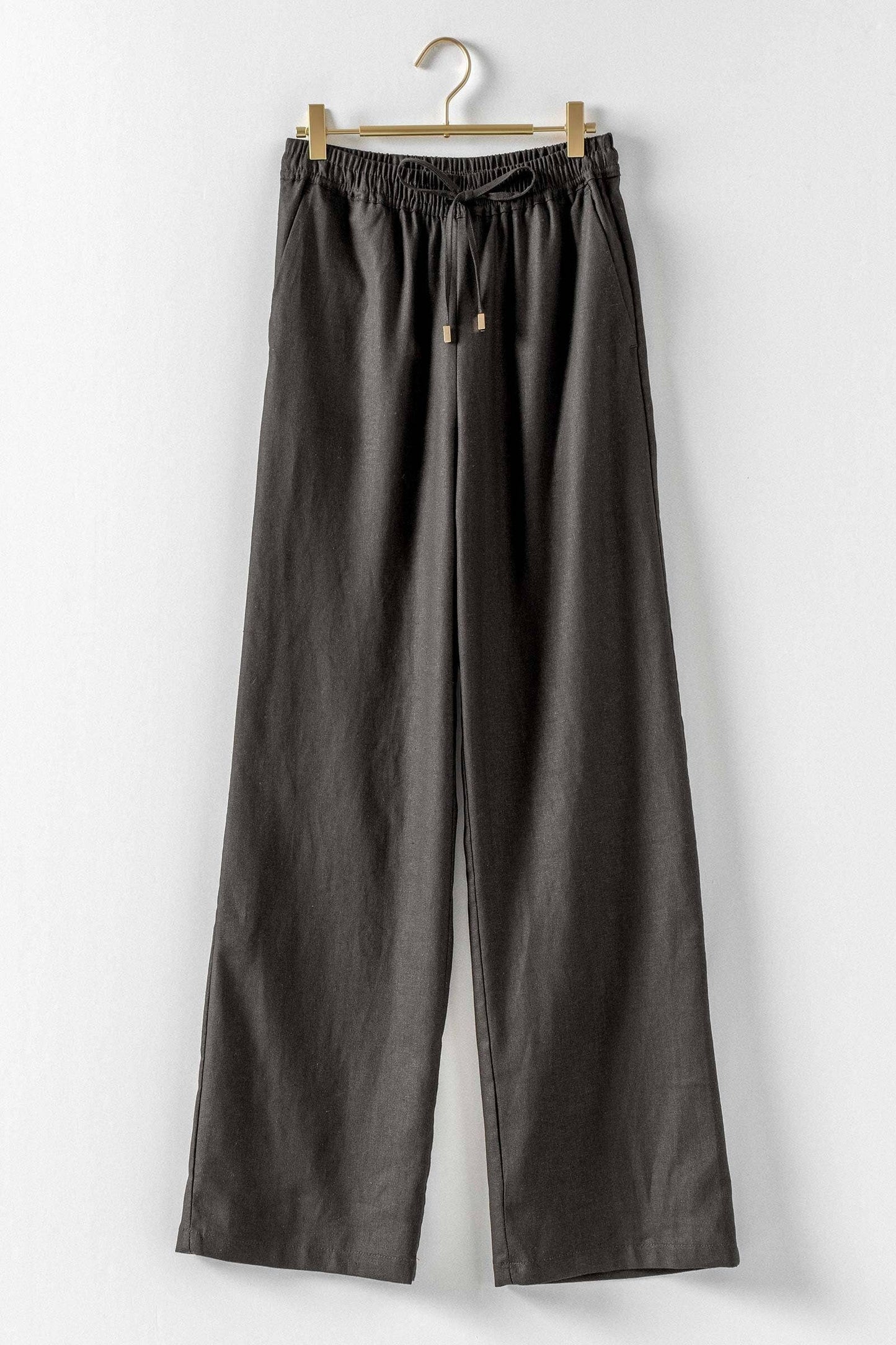 Loose-fitting dark gray linen blend wide leg pants with elastic waistband and drawstring. Available in sizes S-XL.