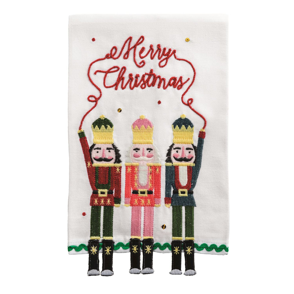 Dangle Embroidery Christmas Towels, a white embroidered hand towel featuring three nutcrackers holding a “Merry Christmas” string with dangling legs.