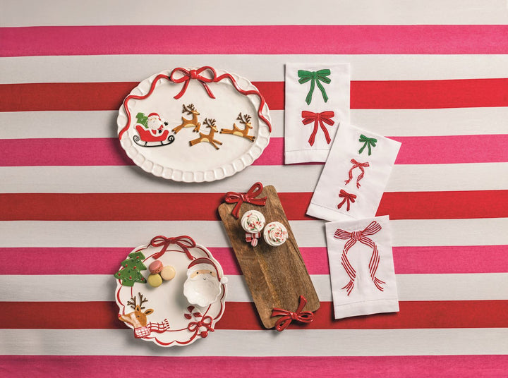 Three rectangular bow-embroidered white towels with red and green designs.