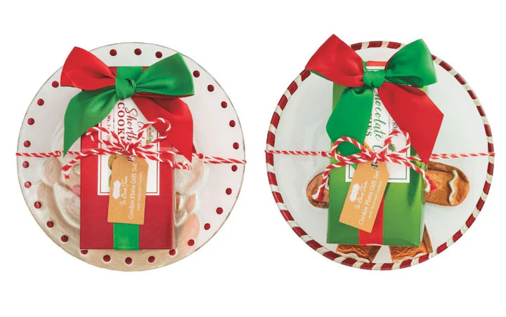 Holiday Gourmet Cookie Plate set featuring two round ceramic plates, one with a red polka-dot rim and one with a red-and-white striped rim, each with a gift box and bow.