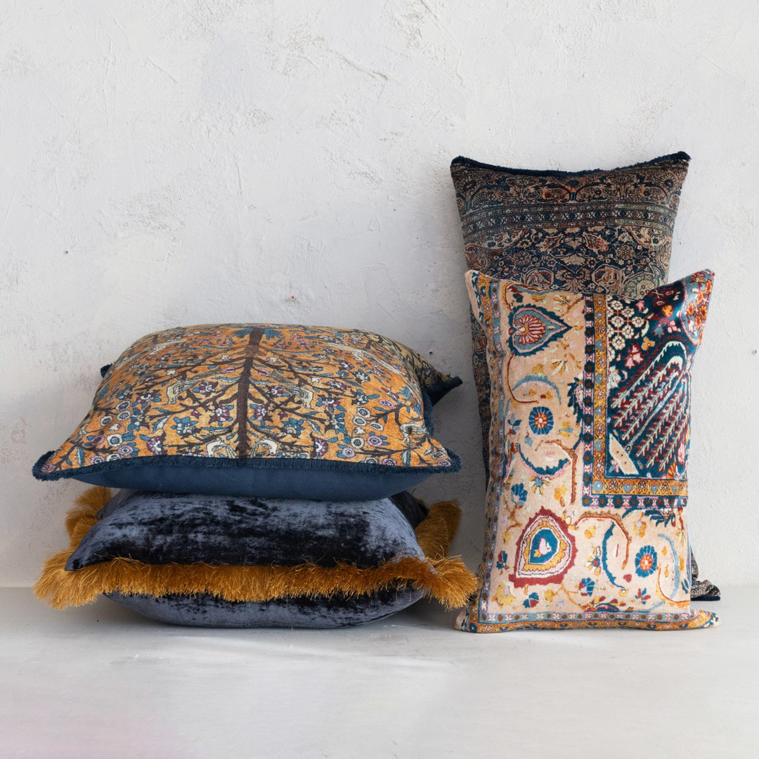 Four 20” cotton blend velvet pillows with ornate vintage-inspired motifs and fringe, available in rich colors and intricate designs.