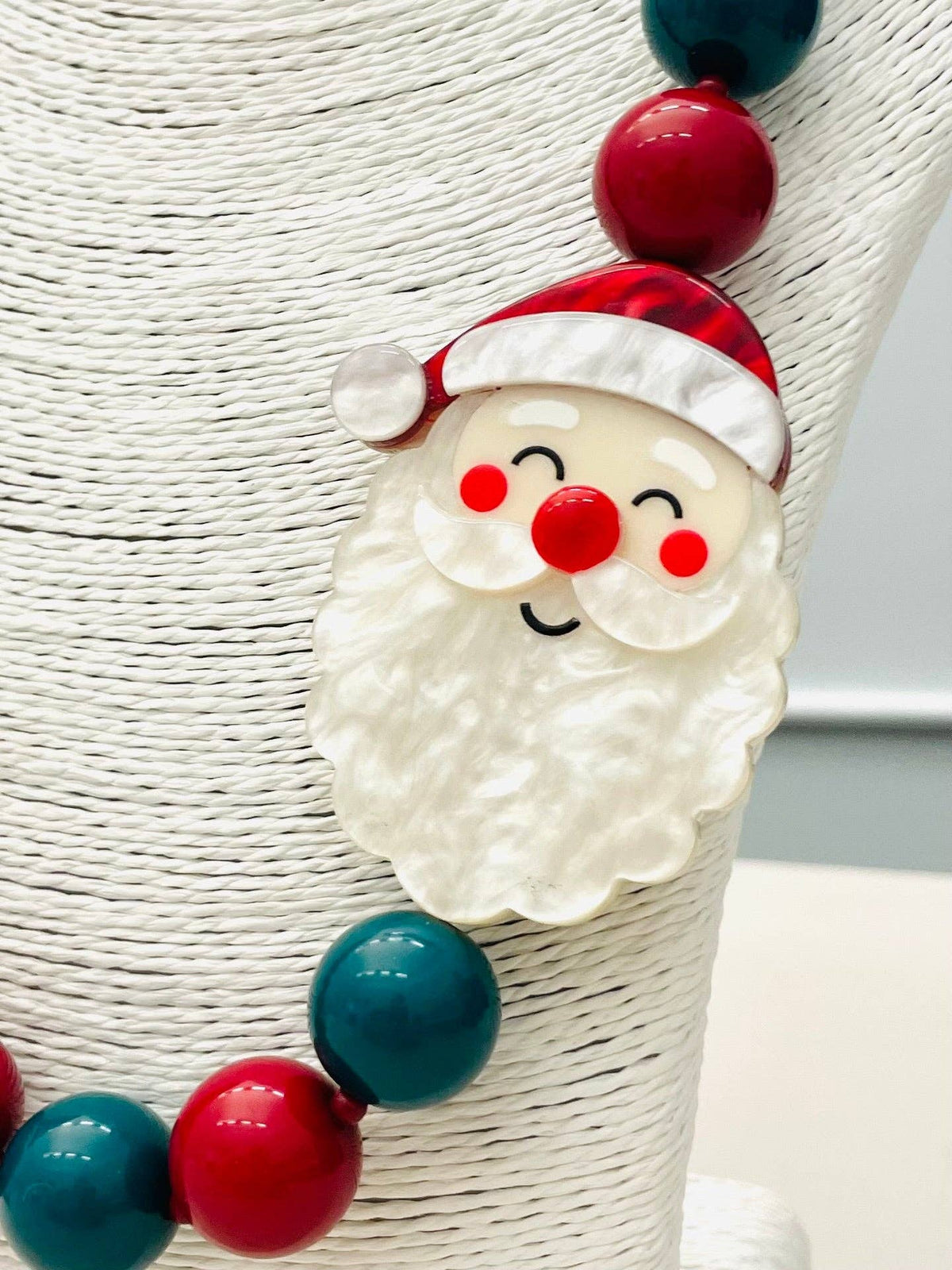 HOLIDAY - Beaded Santa Necklace (red/green) BNK1213 features a smiling Santa pendant with a red hat and rosy cheeks. Available in multiple sizes.