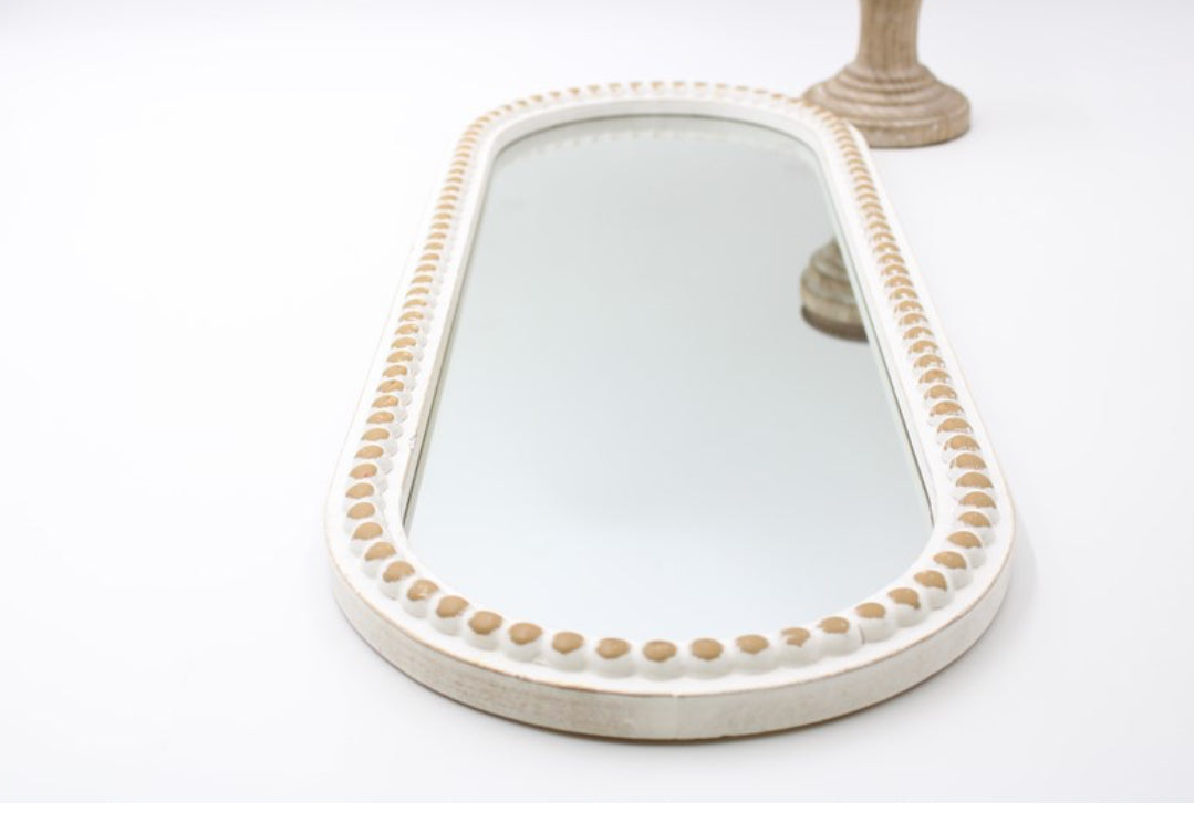 This product is a 9 x 24 oval mirror, elegantly crafted with a finely beaded frame. The mirror's detail adds a touch of sophistication and can seamlessly blend with any decor style. Comes in one size.