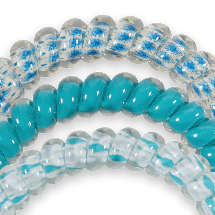 Three TELETIES Hair Ties: two blue/white patterned, one solid turquoise. Available in small and large sizes.
