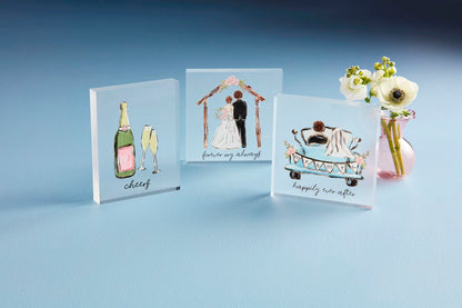 The Acrylic Wedding Plaque showcases hand-painted wedding illustrations like a champagne bottle, a couple under an arch, and "happily ever after" on a car. Available sizes: 8"x10", 12"x15", 16"x20".