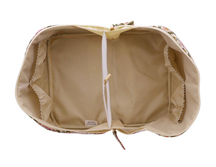 The Travel Organizer | Large has an open floral pattern, beige interior, central zippered pocket, and elastic side pockets. Available in large size.