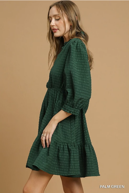 Palm Green Babydoll Dress: textured, loose fit, knee-length, three-quarter sleeves, ruffled hem. Sizes: XS-XL.
