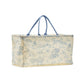 The Animal Toile Hamper/Storage Tote is a rectangular fabric storage bag with blue handles and a scenic pattern of outdoor scenes on a light yellow background. Its structured design allows it to stand upright independently, perfect for nursery storage. Available sizes: Medium, Large.
