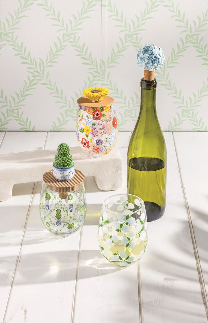 Wine Glass &amp; Topper Set: four glass containers with floral/cactus designs, two with flower cork stoppers. Sizes available.