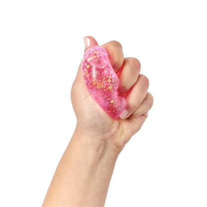 The Heart Jellies Glitter Squishy Heart features sparkling glitter and gold accents for a mesmerizing visual experience. Available in one size.