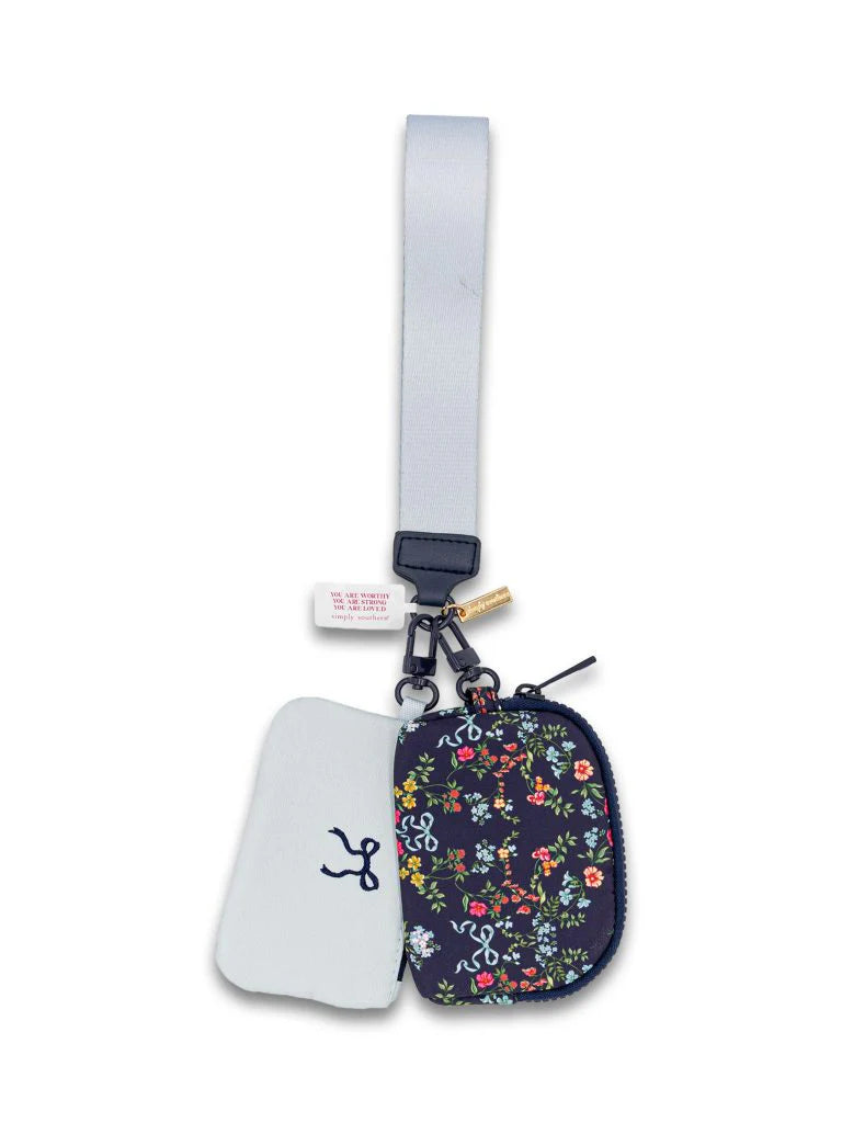 Ribbon and Flowers ID Coin Wristlet with small floral print, light gray strap, white tag, partially open to reveal white interior with blue pattern. Available in one size.