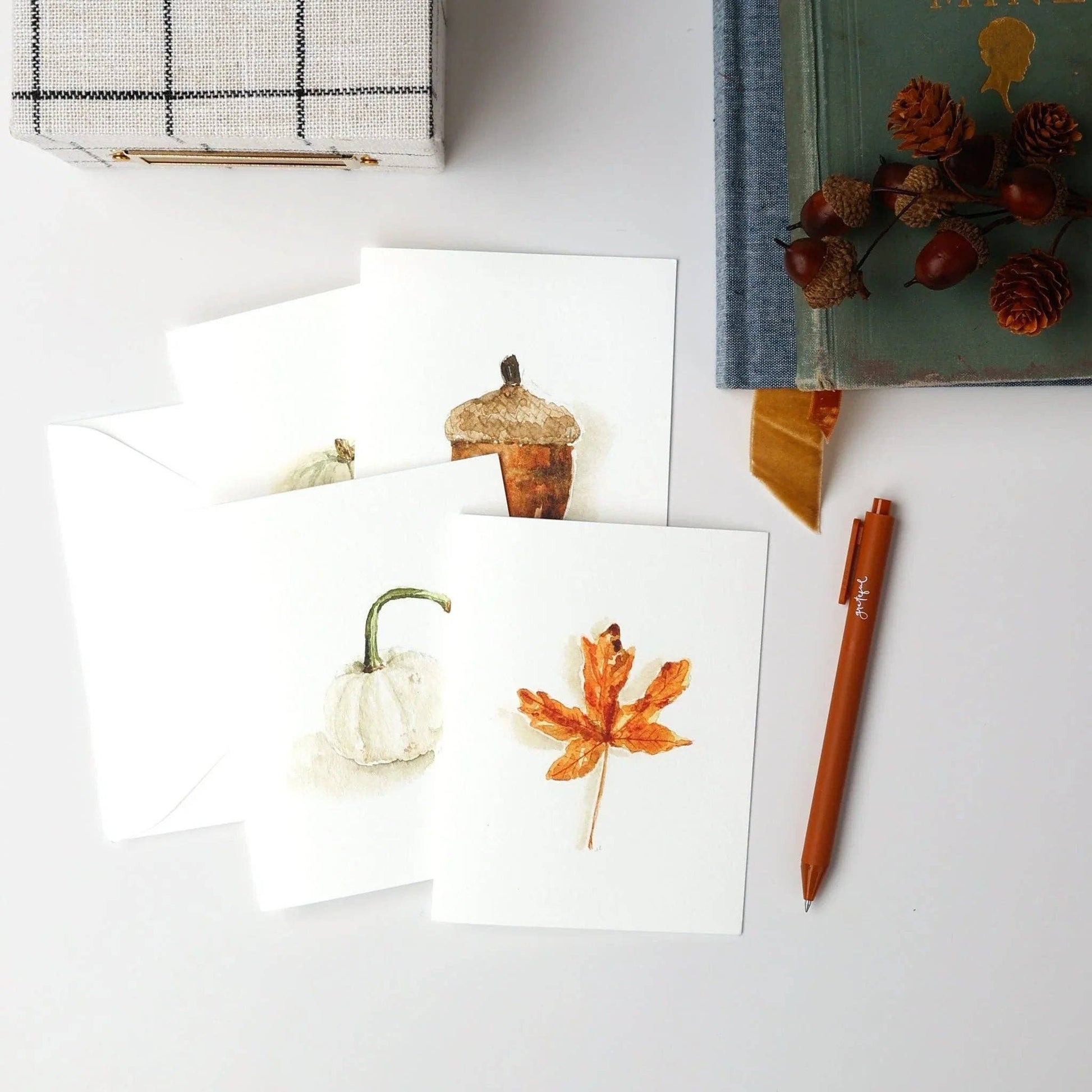 Autumn assorted notecard set includes four watercolor cards featuring a pumpkin, acorn, white gourd, and orange leaf. Blank inside for messages; sizes available upon request.