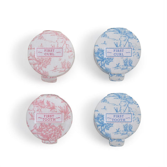 Set of four round boxes (two pink, two blue) with toile patterns, labeled "FIRST CURL" or "FIRST TOOTH." Sizes not listed.