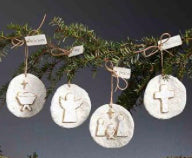 Four round, glittery white papier-mâché ornaments with embossed religious figures and twine hangers with gift tags.