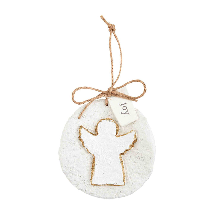Round white glitter papier-mâché ornament with an angel cutout and “joy” tag, hanging from a jute twine loop.