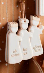 Three white stoneware Nativity king ornaments engraved with “oh come let us adore him.”.