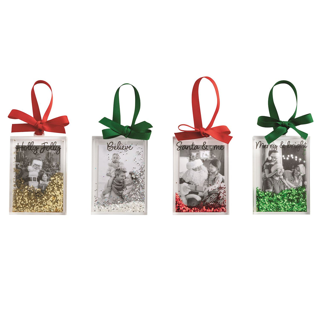 Four rectangular Christmas glitter photo ornaments with colored bows, black-and-white photos, and loose glitter.