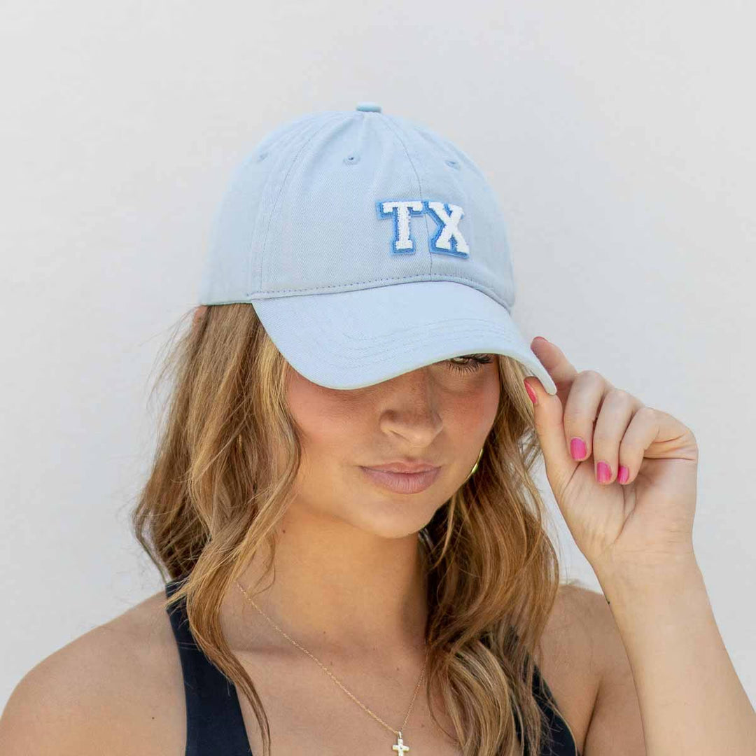 Texas Baseball Hat with light blue "TX" embroidery. Available in S, M, and L.