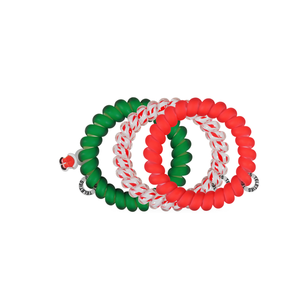 Four large spiral coil Claus I said So hair ties in solid green, solid red, and candy cane striped patterns.