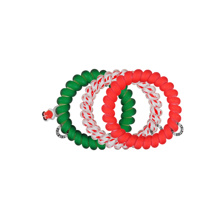 Four large spiral coil Claus I said So hair ties in solid green, solid red, and candy cane striped patterns.