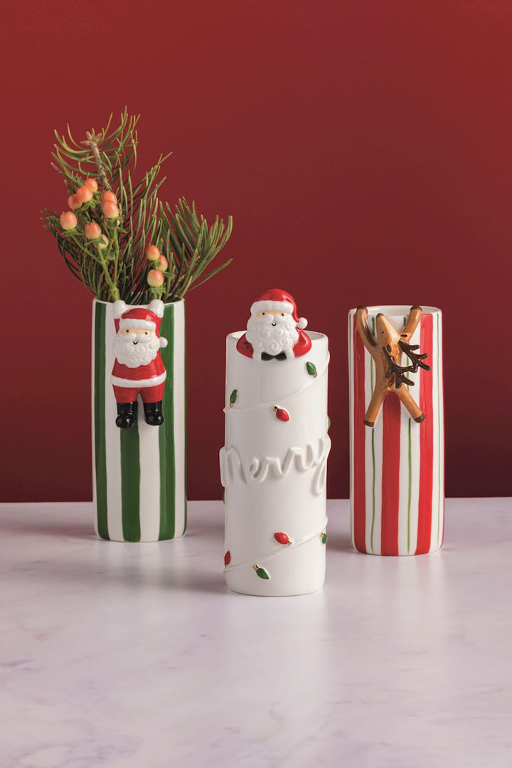 Three hanging ceramic cylindrical vases featuring Santa and reindeer designs with red or green vertical stripes or Christmas lights.