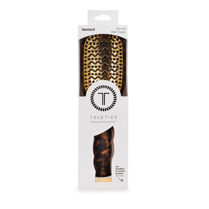 The Vented Hair Brush | Tortoise has a tortoiseshell pattern, a quick-heat aluminum plate, and comes in white TELETIES packaging with the logo and product details. Available sizes: Regular and Large.