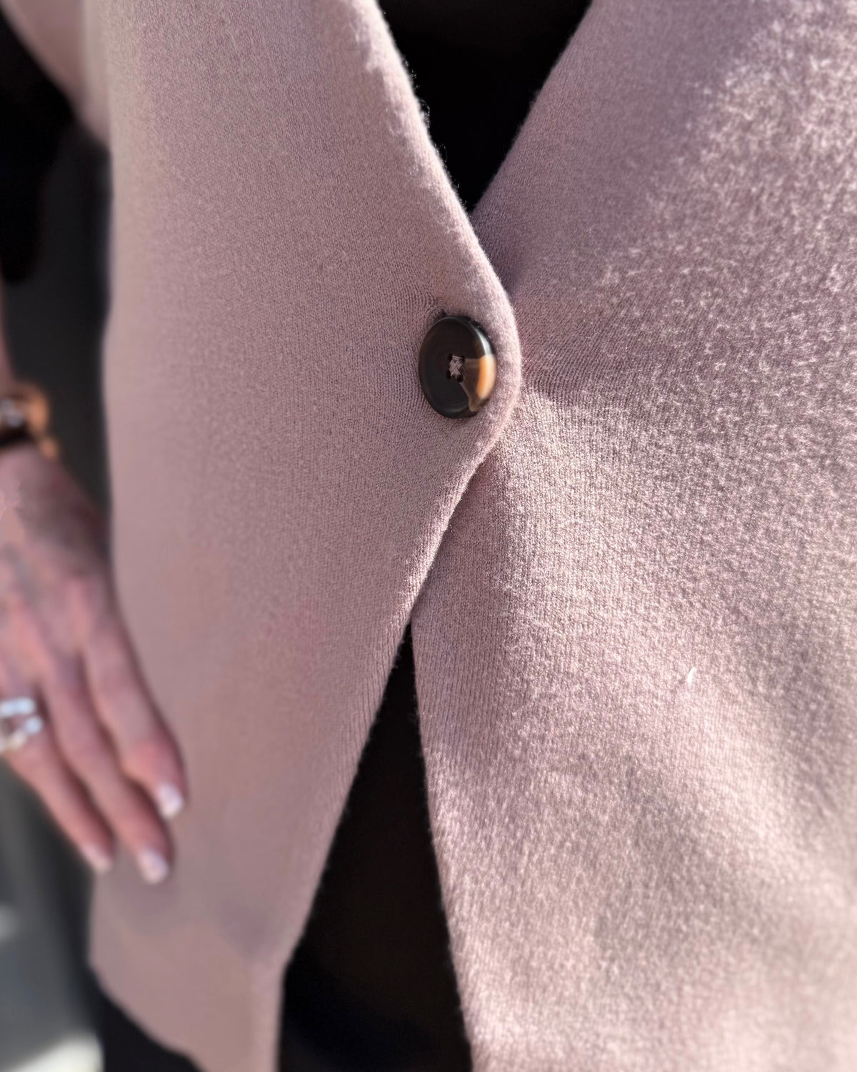Light mauve coat with a single dark button closure, available in sizes XS–XL.