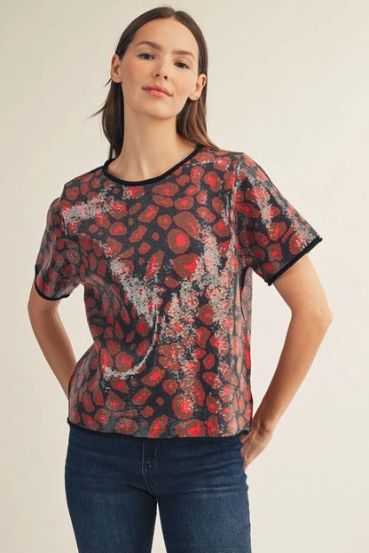 Red Sequin Covered Leopard Sweater Top with bold red and black leopard print, shimmering sequins, and black trim. Available in sizes XS-XL.