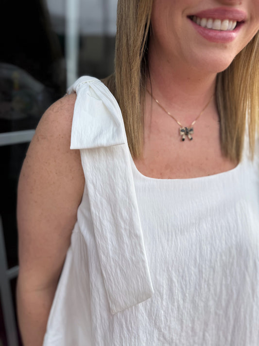 White Scoop Neck Bow Shoulder Top with a tied strap detail. Available in sizes XS-XL.