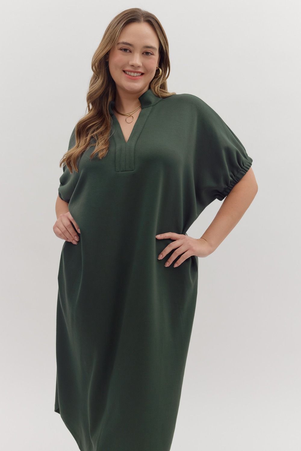 Forest green Collie Midi Dress with V-neck, band collar, lightweight knit, and gathered short sleeves. Available in all sizes.