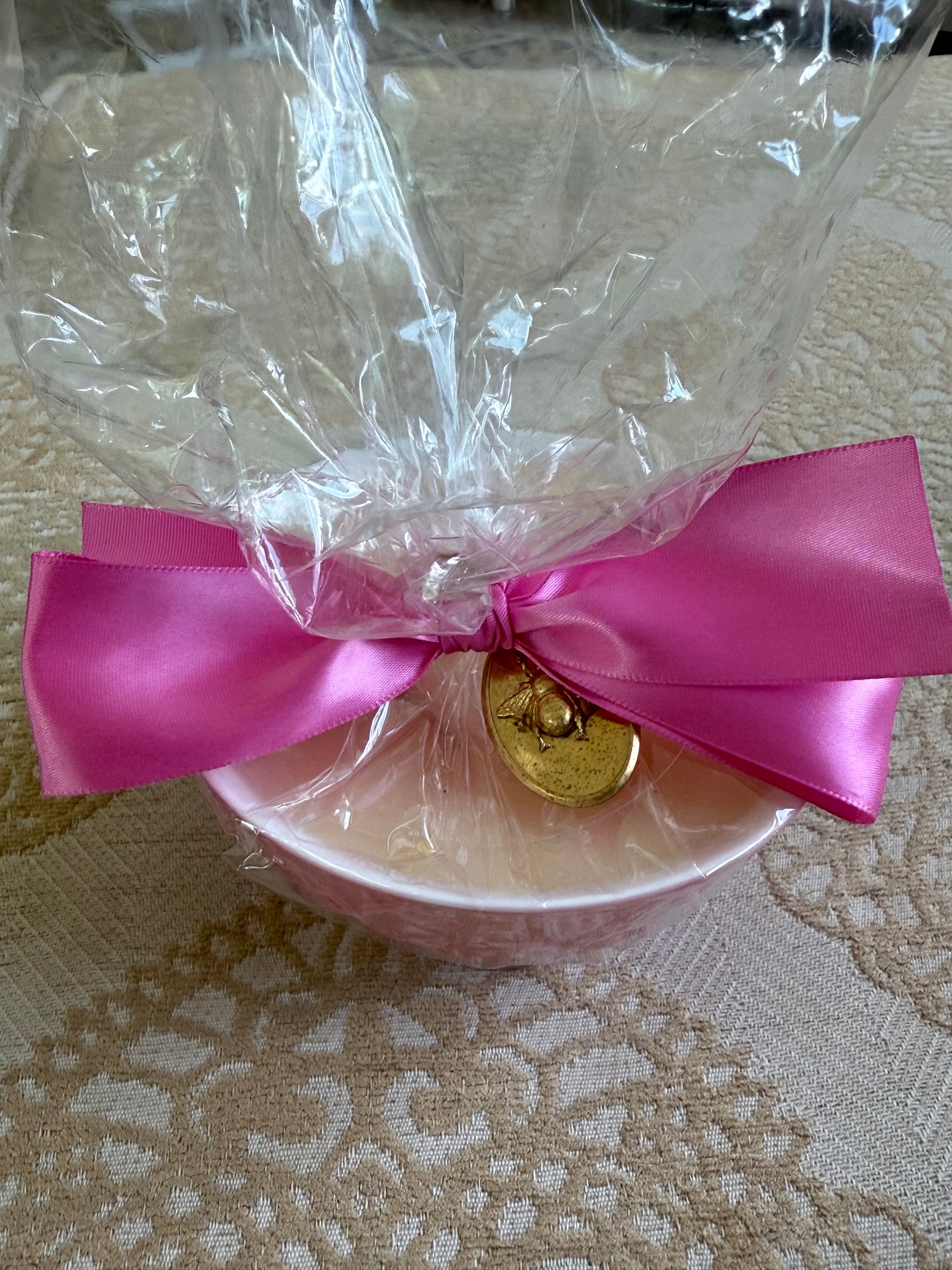 Pink bowl styled like French Bee Candles, wrapped in cellophane with pink ribbon and gold medallion; available in 2 sizes.