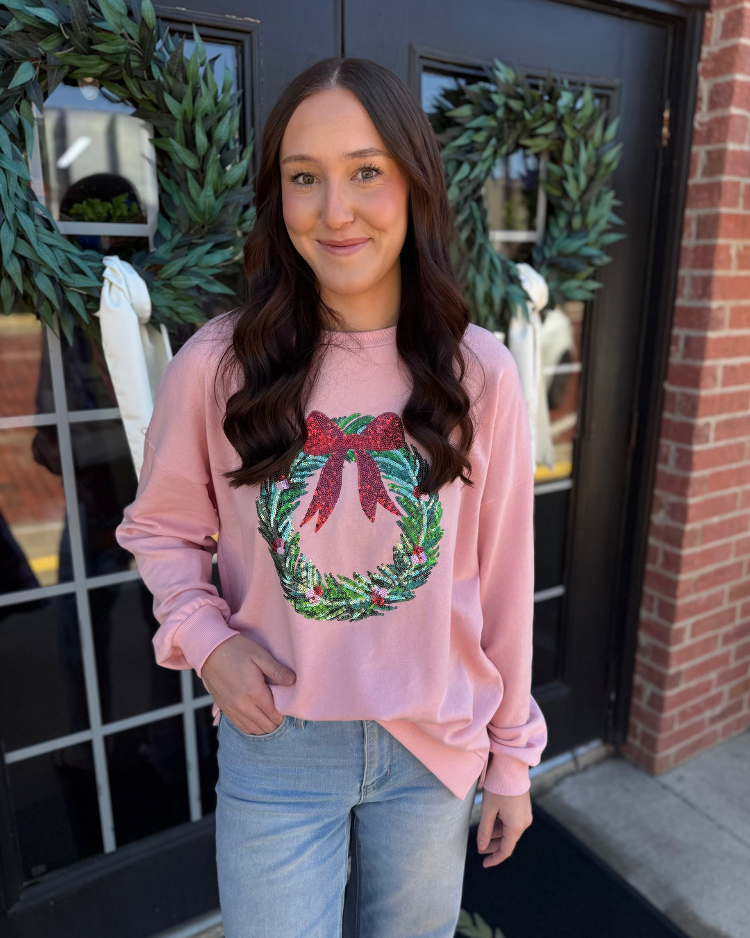 Light pink Clara Wreath Sequin Sweatshirt featuring a large sequined Christmas wreath. Available in multiple sizes.