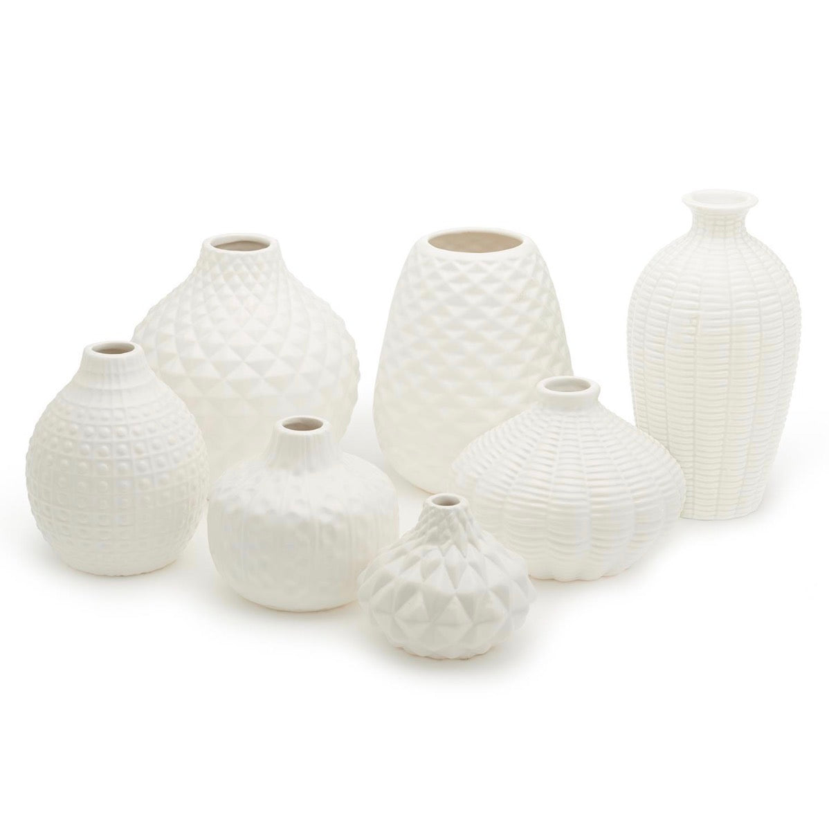 Seven artisan carved vases in white ceramic with unique textures and distinctive shapes, available in multiple sizes.