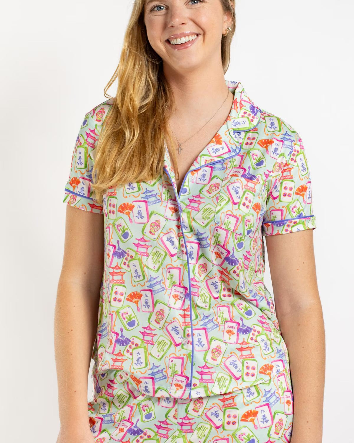 Mahjong Dreams Short Sleeve top with vibrant Mahjong tile pattern on a white background, available in sizes XS–XL.