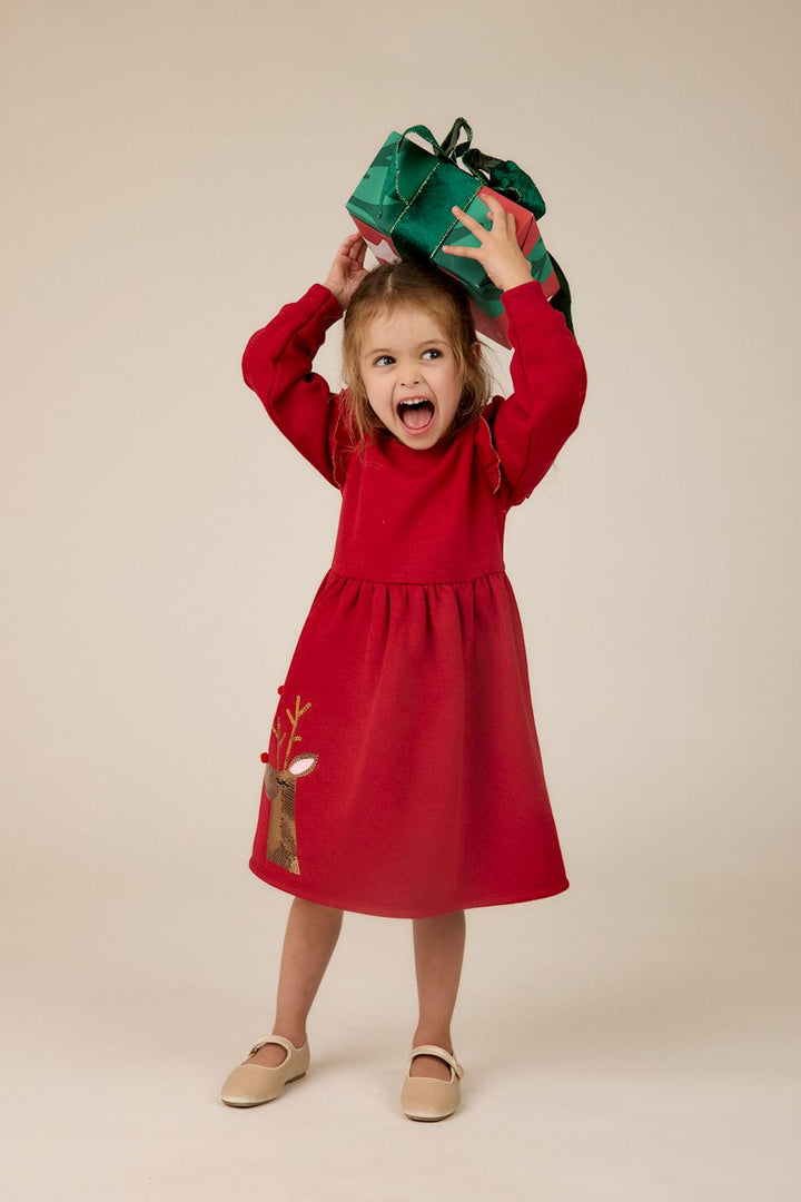 Red Sequin Reindeer Ruffle Dress with long sleeves, ruffled shoulder detail, and sequined reindeer graphic on the skirt. Available in multiple sizes.