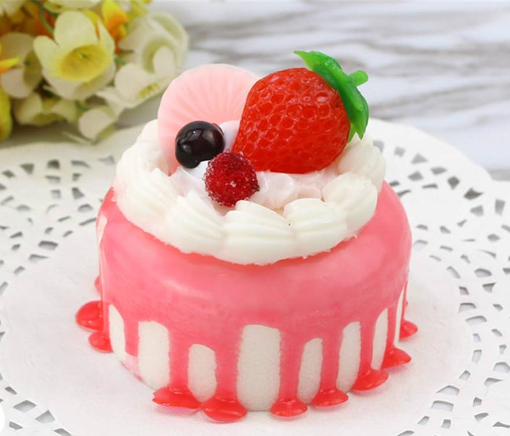 Small round faux cake with white and pink icing, strawberry, whipped cream, fruit. Available sizes: small.