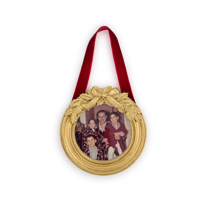 Round gold holly leaves ornament photo frame with a holly leaf bow and red velvet ribbon.