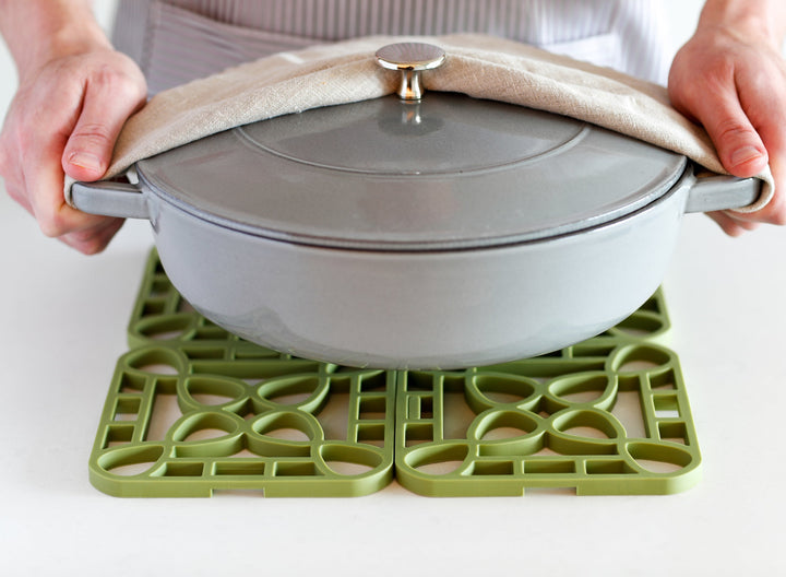 Gray Dutch oven with lid being lifted. Available in 4, 6, and 8 qt sizes.