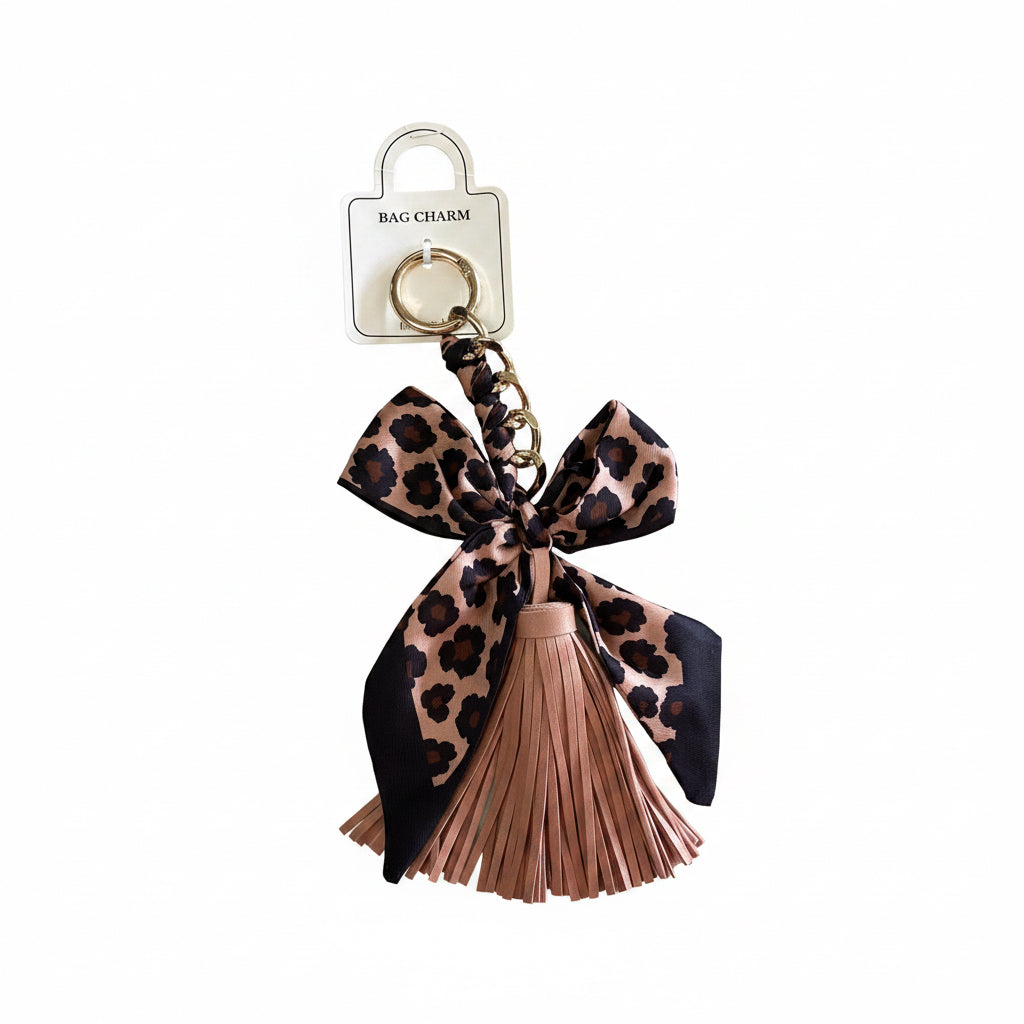 Gold keyring with pink faux leather tassel and large pink and black leopard print bow. Available in one size.