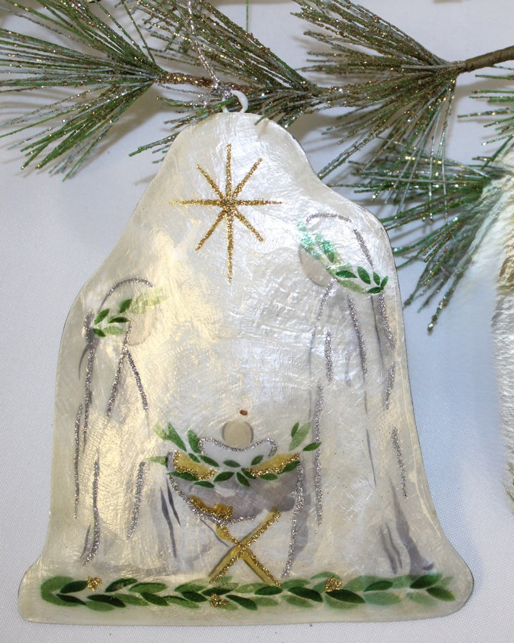 Bell-shaped Holy Family Capiz ornament with painted scene and gold glitter star.