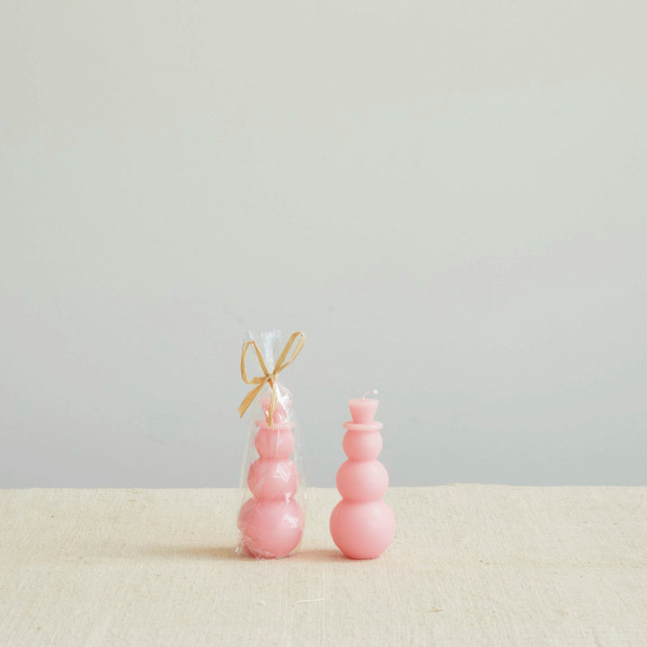 Two pink snowman-shaped candles.
