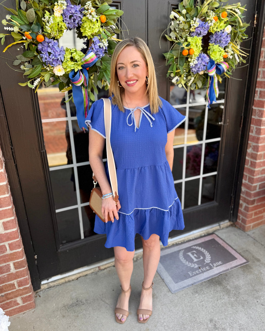Lillian Blue Dress features a tiered silhouette. Available in sizes XS–XL.