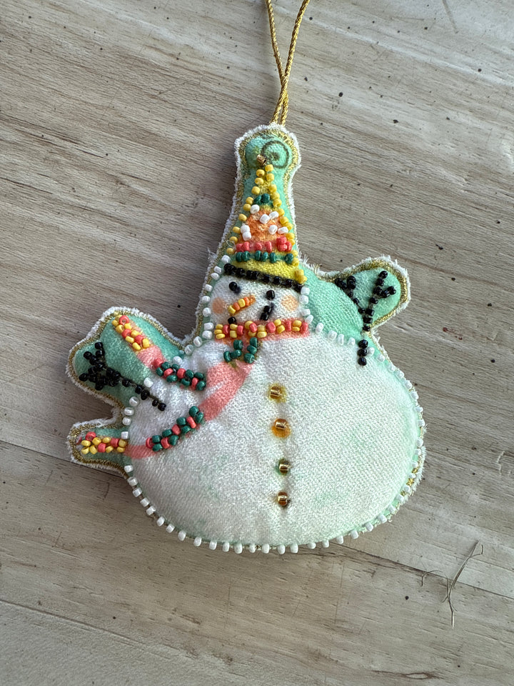 Cotton velvet snowman ornament with embroidery, glass beads, patterned hat, and scarf.
