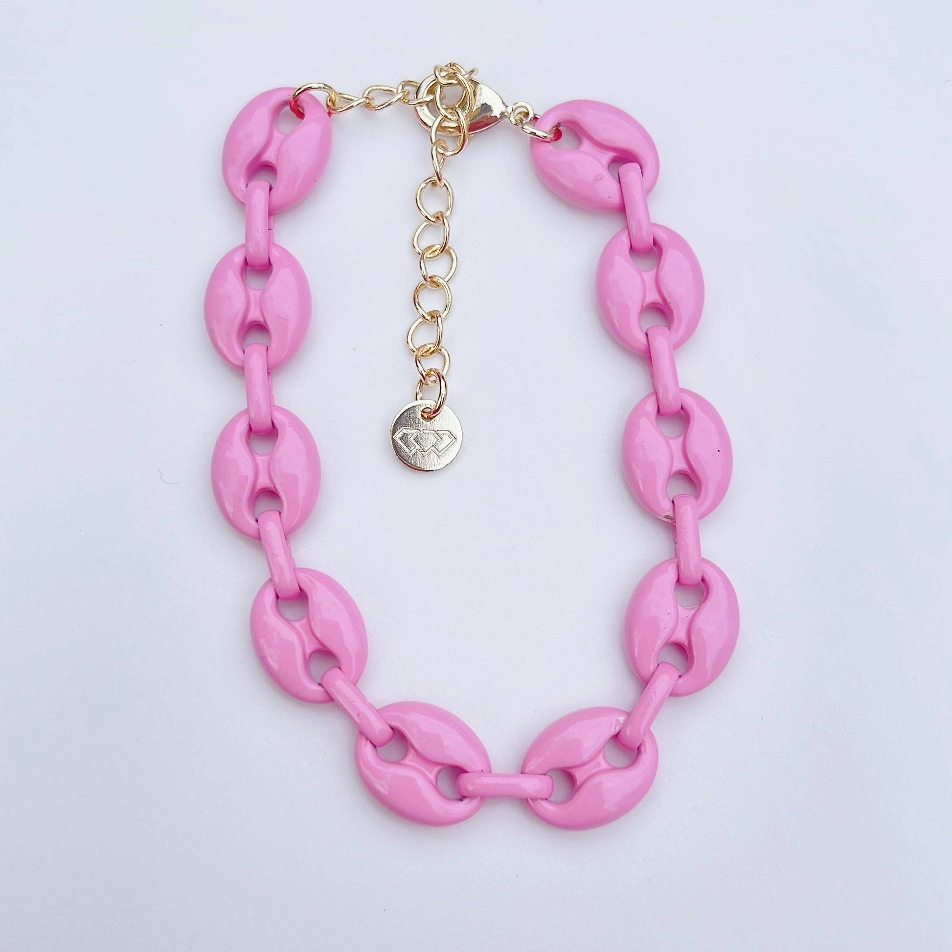 The Pink Link Bracelet has chunky pink oval links, gold adjustable clasp, heart charm. Available in S, M, and L sizes.